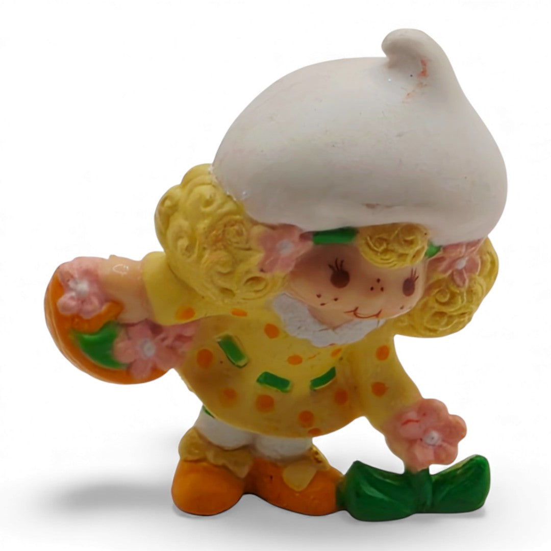 Vintage 1980s mini pvc figure. Strawberryland Miniatures. Lemon Meringue. Picking Flowers 2". Front view.