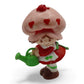 Vintage 1980s mini pvc figure. Strawberryland Miniatures. Strawberry Shortcake. Watering Can 2". Front view.