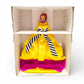 Barbie doll in a yellow dress with a striped bow in an open cardboard box.
